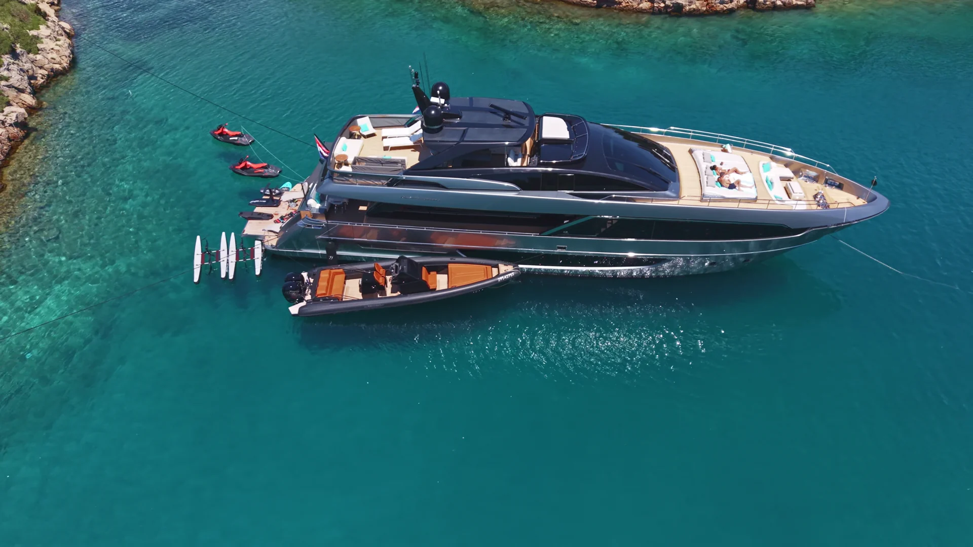 YOYITA II at anchor in turquoise water with her tender and water toys