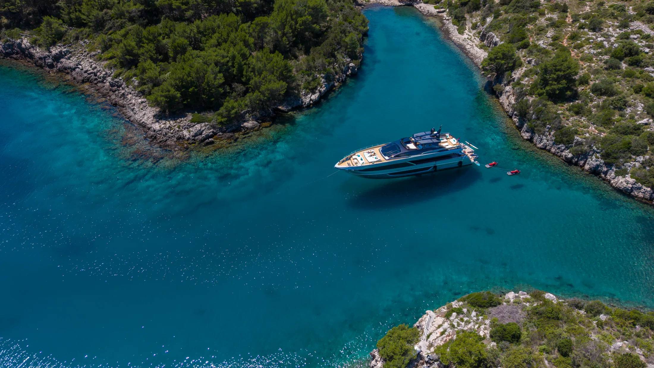 YOYITA II moving between two wooded islands in clear Adriatic water