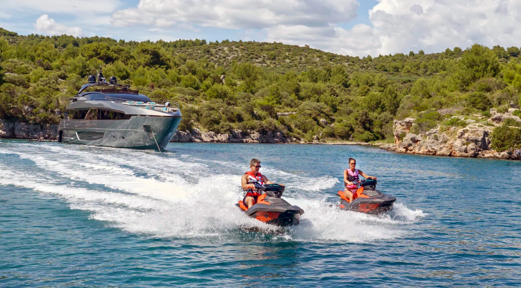 Guests riding jet skis beside YOYITA II